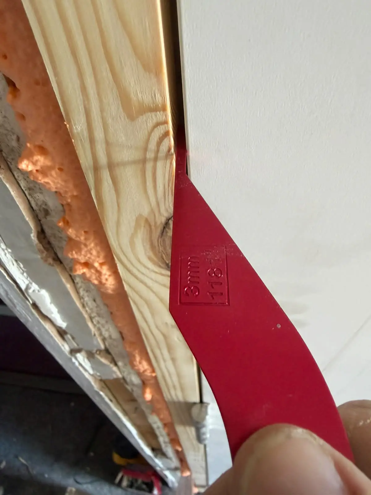 Door inspection detail showing a gauge between the door edge and timber frame